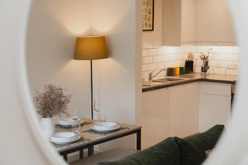 a kitchen with a table with two plates on it at Duplex Redhill town centre apartment by Livingo Stays in Redhill