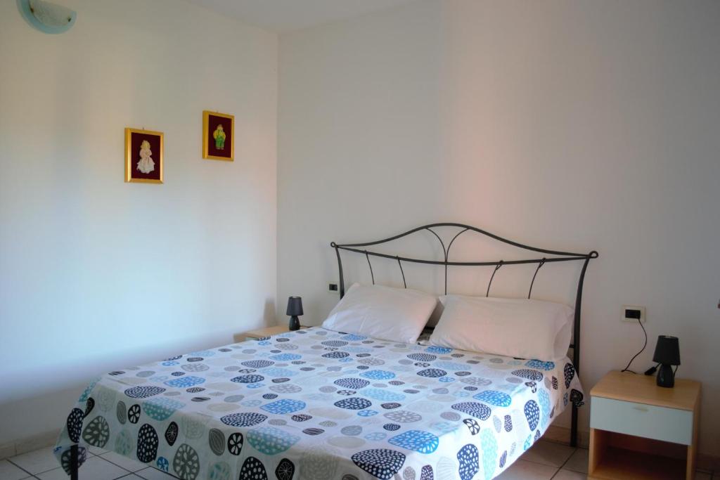 a bedroom with a bed with a blue and white comforter at Casa la Gabbianella in San Teodoro
