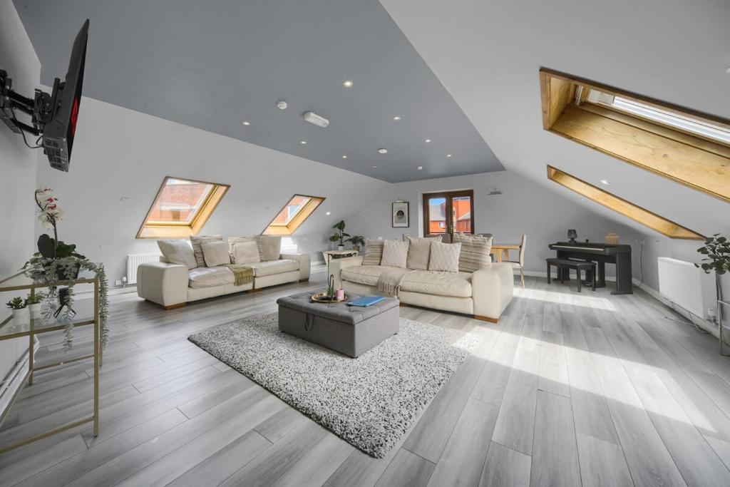 ein großes Wohnzimmer mit Sofas und einem Tisch in der Unterkunft Luxury Penthouse Suite - Swansea Central - Beach in Swansea