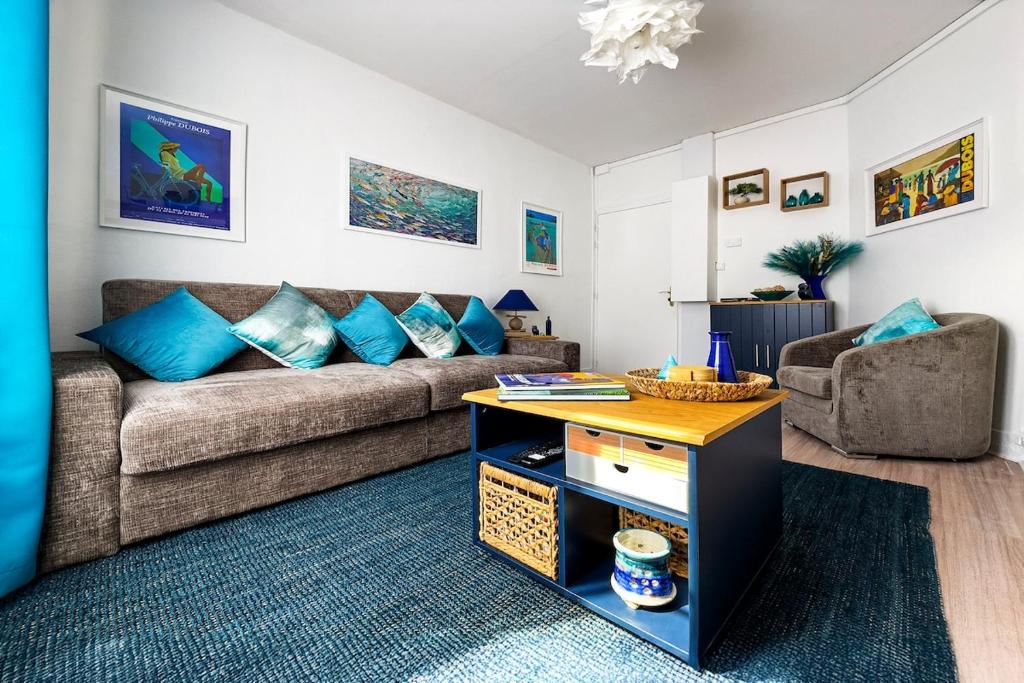 a living room with a couch and a table at Ohana in Deauville