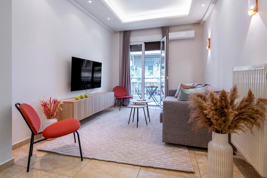 a living room with a couch and red chairs at Stylish 2BDR Exarchia Apt with Balcony and Workspace in Athens