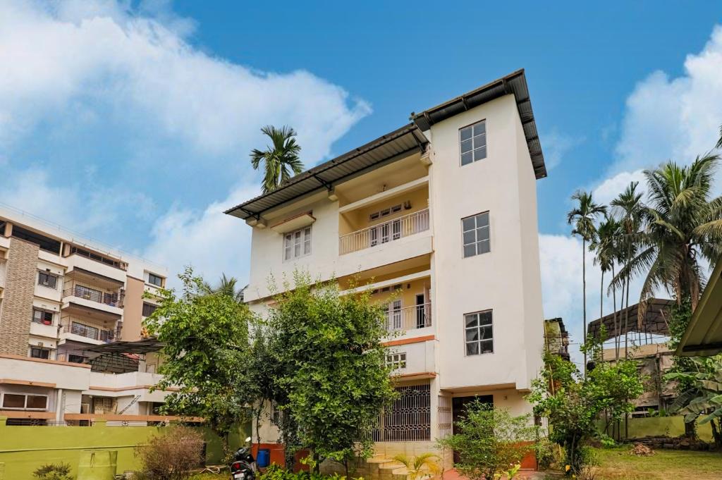a white building with trees in front of it at GREEN VISTA HOMESTAY in Guwahati