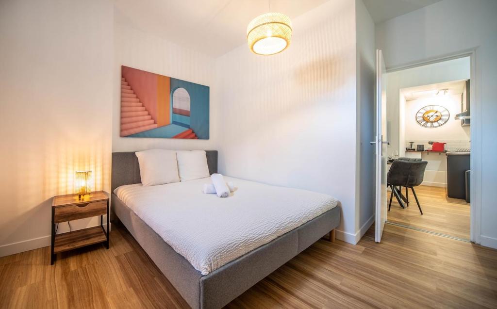 ein Schlafzimmer mit einem Bett und einem Tisch darin in der Unterkunft La Citadine in Chalon-sur-Saône