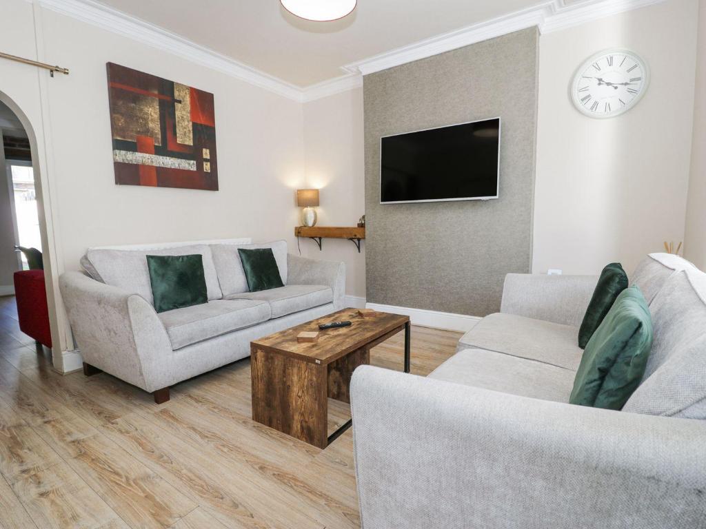 a living room with two couches and a tv at Llandudno 3 Bedroom Holiday Apartment in Town Centre in Llandudno