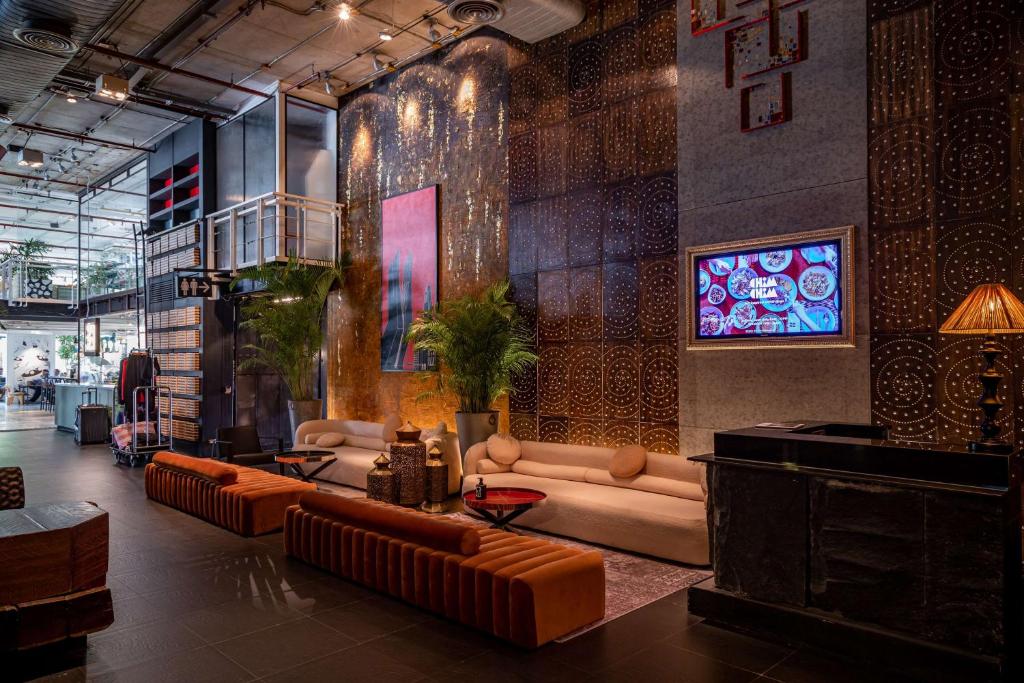 a living room with couches and a tv in it at Siam@Siam, Design Hotel Bangkok in Bangkok