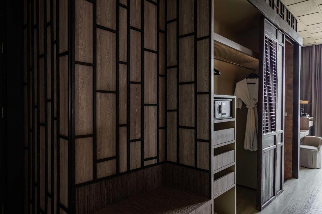 a room with a wall with a partition with wooden panels at Siam@Siam, Design Hotel Bangkok in Bangkok