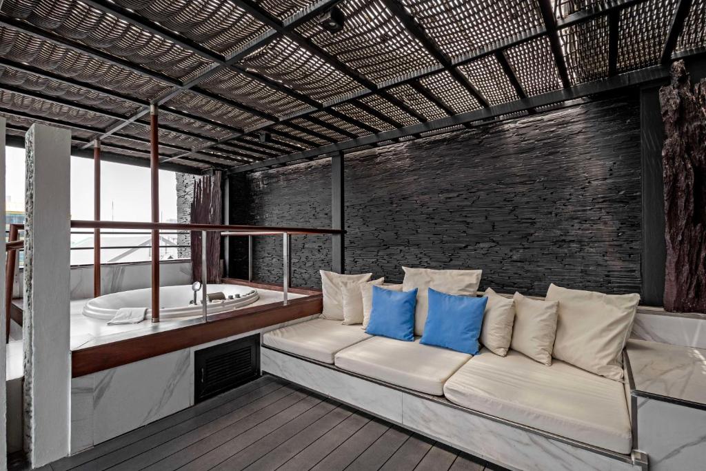 a living room with a couch and a bath tub at Siam@Siam, Design Hotel Bangkok in Bangkok