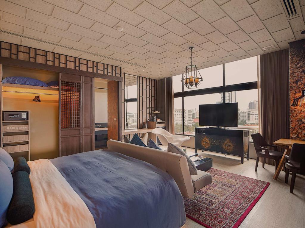 a bedroom with a large bed and a living room at Siam@Siam, Design Hotel Bangkok in Bangkok