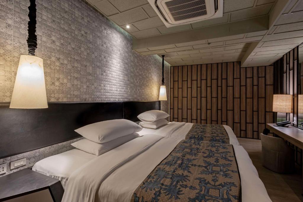 a bedroom with a large bed with white sheets and pillows at Siam@Siam, Design Hotel Bangkok in Bangkok