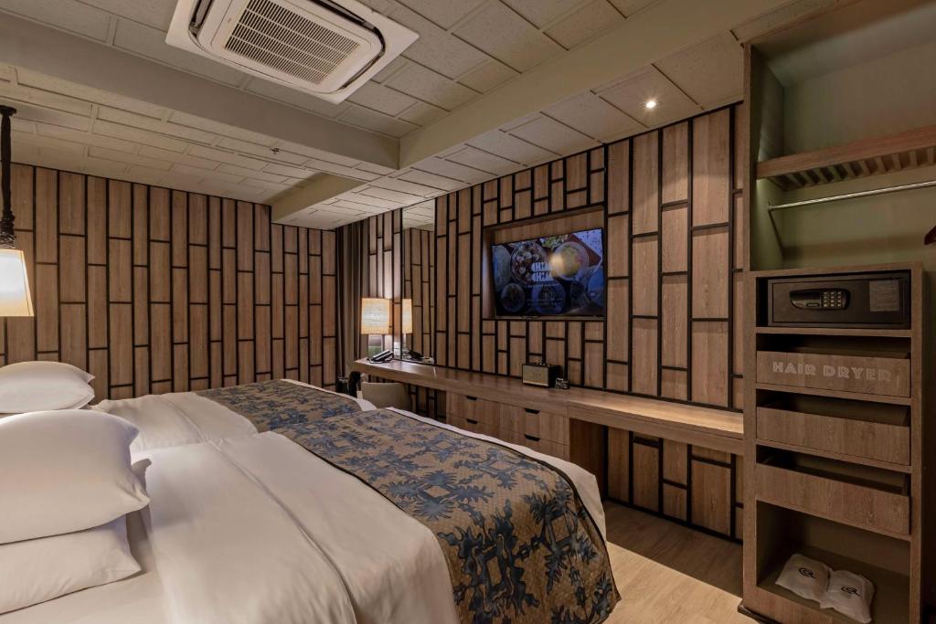 a hotel room with a bed and a tv at Siam@Siam, Design Hotel Bangkok in Bangkok
