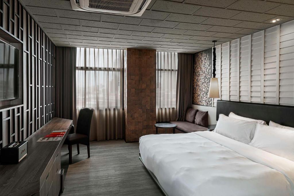 a hotel room with a large bed and a desk at Siam@Siam, Design Hotel Bangkok in Bangkok