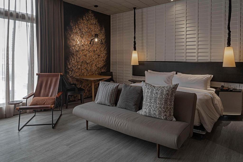 a hotel room with a bed and a couch at Siam@Siam, Design Hotel Bangkok in Bangkok