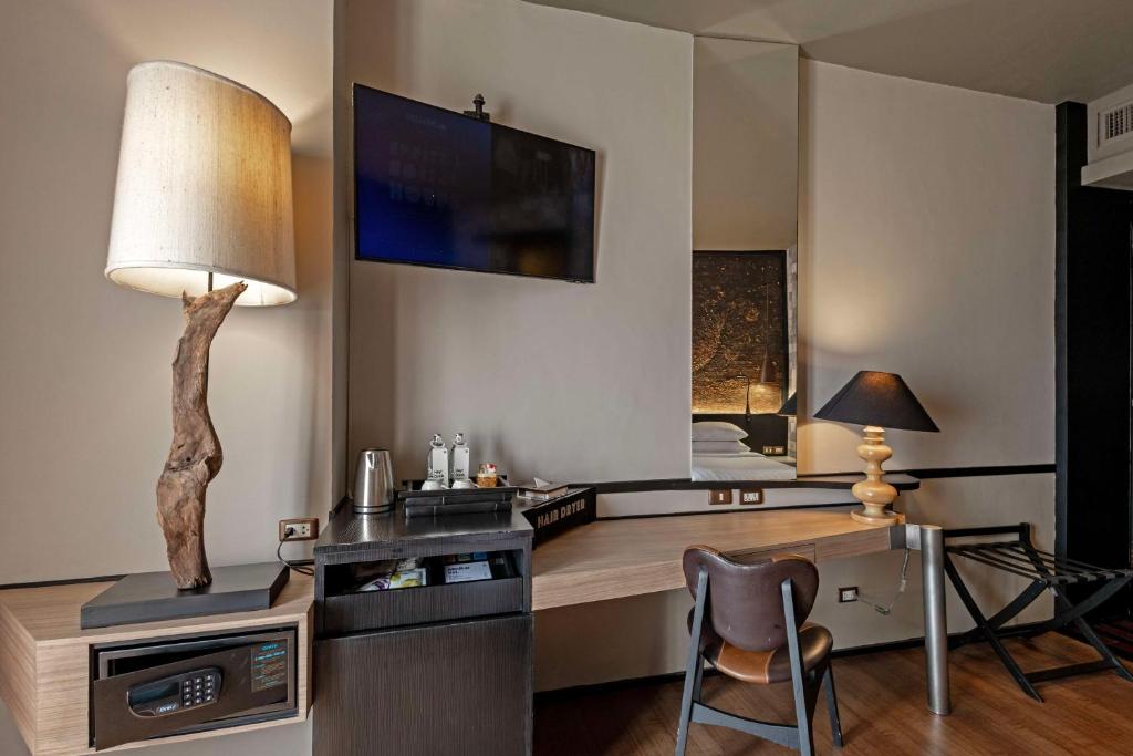 a room with a desk with a lamp and a bed at Siam@Siam, Design Hotel Bangkok in Bangkok