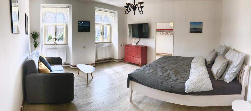 a bedroom with a bed and a living room at Apartmány CAFÉ-CAFÉ in Jičín
