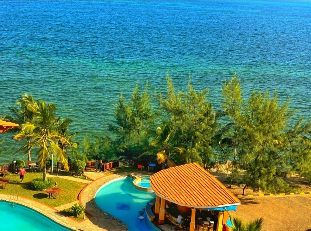 Shanzu Oceanline Apartments and Suites في مومباسا: منظر جوي لمنتجع به حمام سباحة