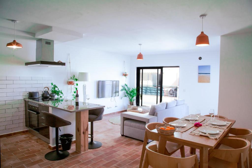 a kitchen and living room with a table and chairs at Mar-Ria 6 in Fuzeta