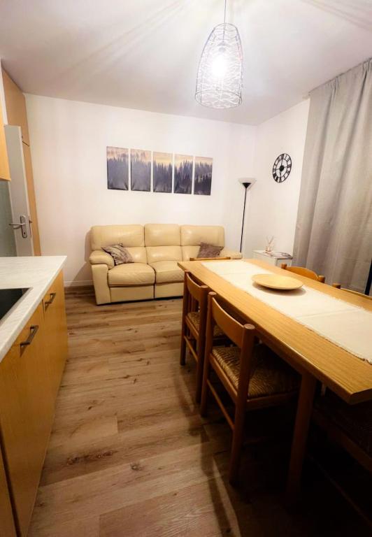 salon ze stołem i kanapą w obiekcie DOLOMIA APARTMENTS Pinzolo w mieście Pinzolo