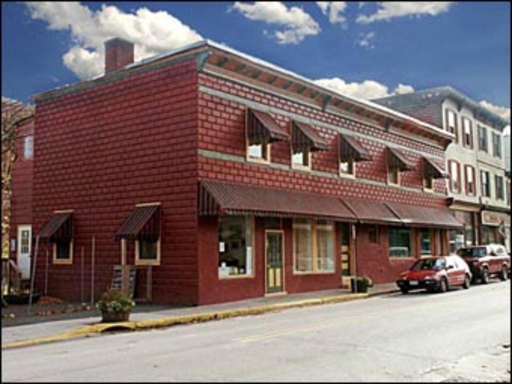 un edificio de ladrillo rojo al lado de una calle en Suites on Main, en Margaretville