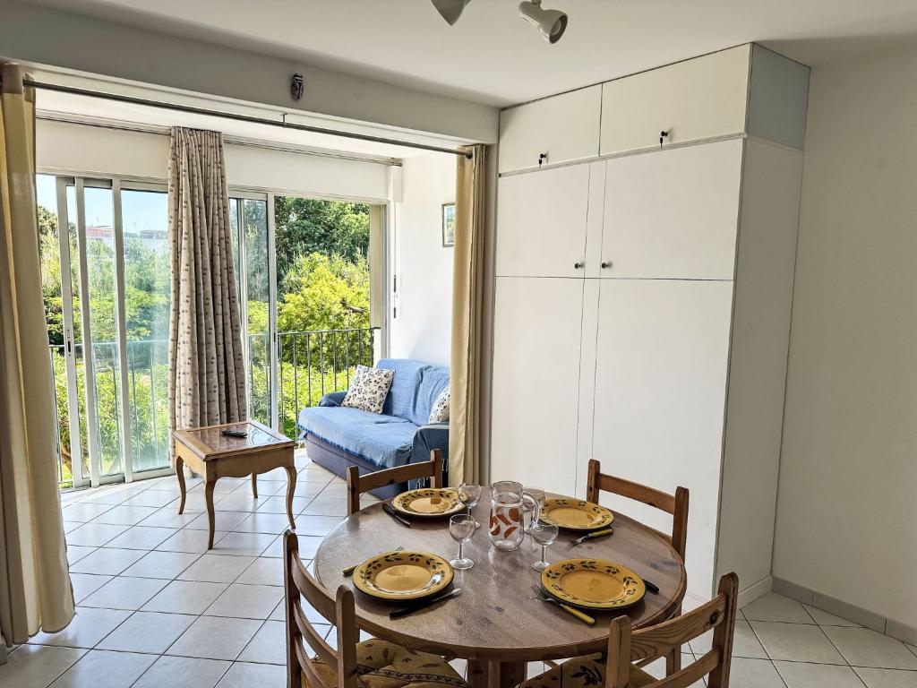 une salle à manger avec une table, des chaises et un canapé dans l'établissement Apartment Les Roses Lauriers by Interhome, au Lavandou