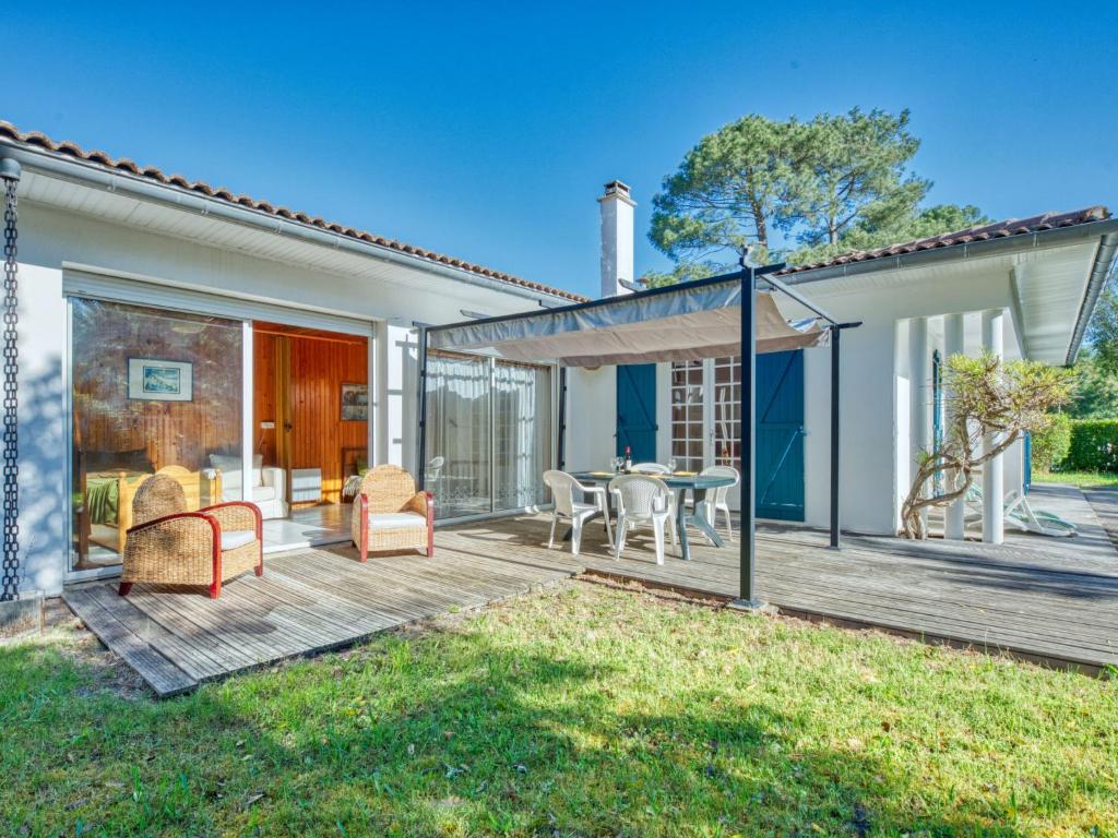 ラカノーにあるHoliday Home L'étang by Interhomeのデッキにテーブルと椅子が置かれたパティオ
