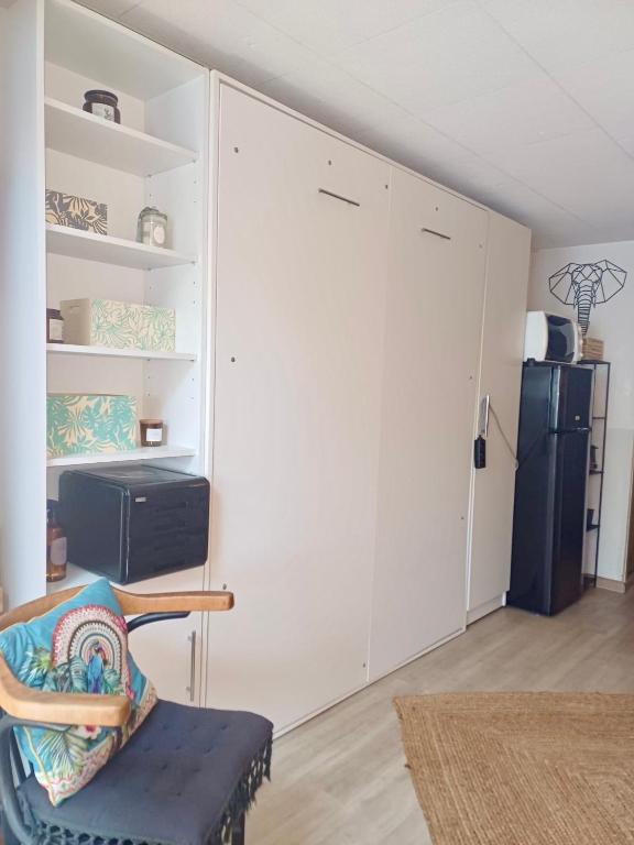 une chambre avec une porte coulissante et une chaise dans l'établissement Escapades Bohème - 3 pers - Histoire de Clés, au Cap d'Agde