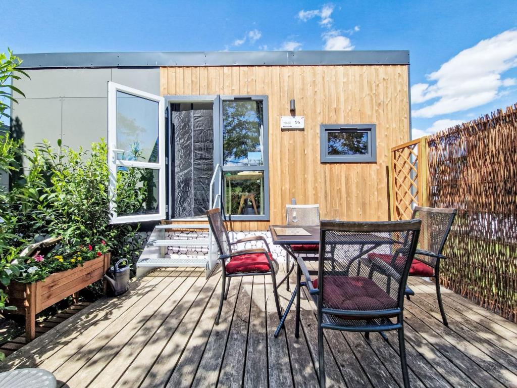 バイルングリースにあるHoliday Home Tiny Haus am Altmühlufer by Interhomeのパティオ(椅子、デッキ上のテーブル付)