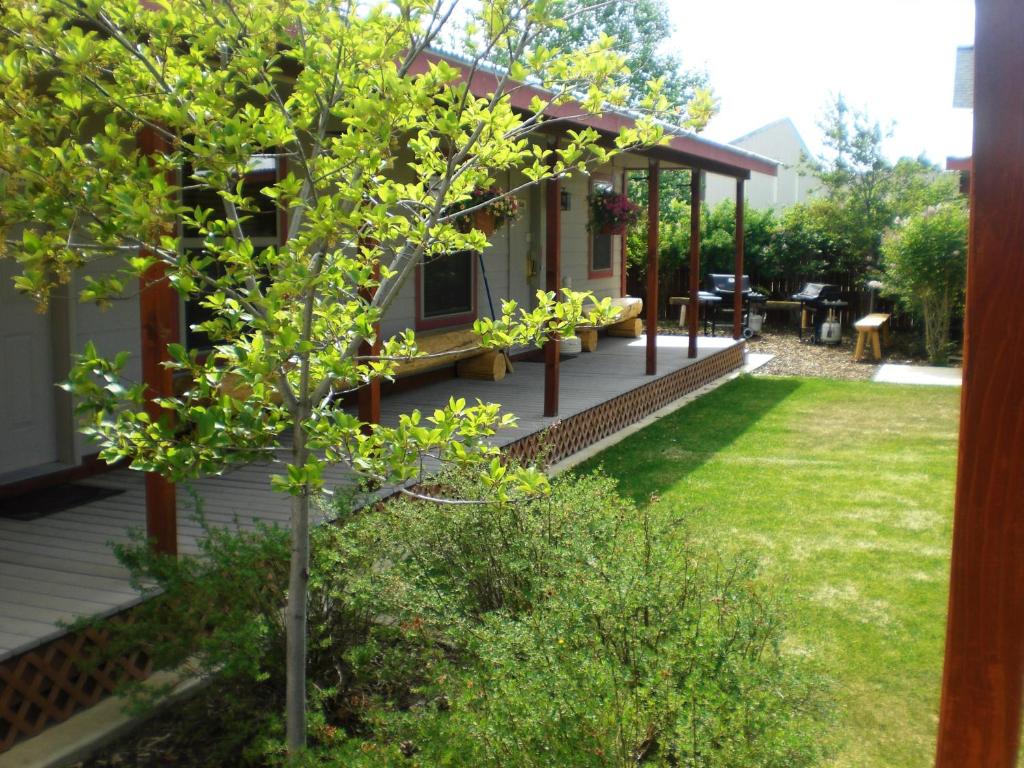 ein Haus mit einer Veranda mit einem Garten mit Gras in der Unterkunft Pinedale Cozy Cabins in Pinedale