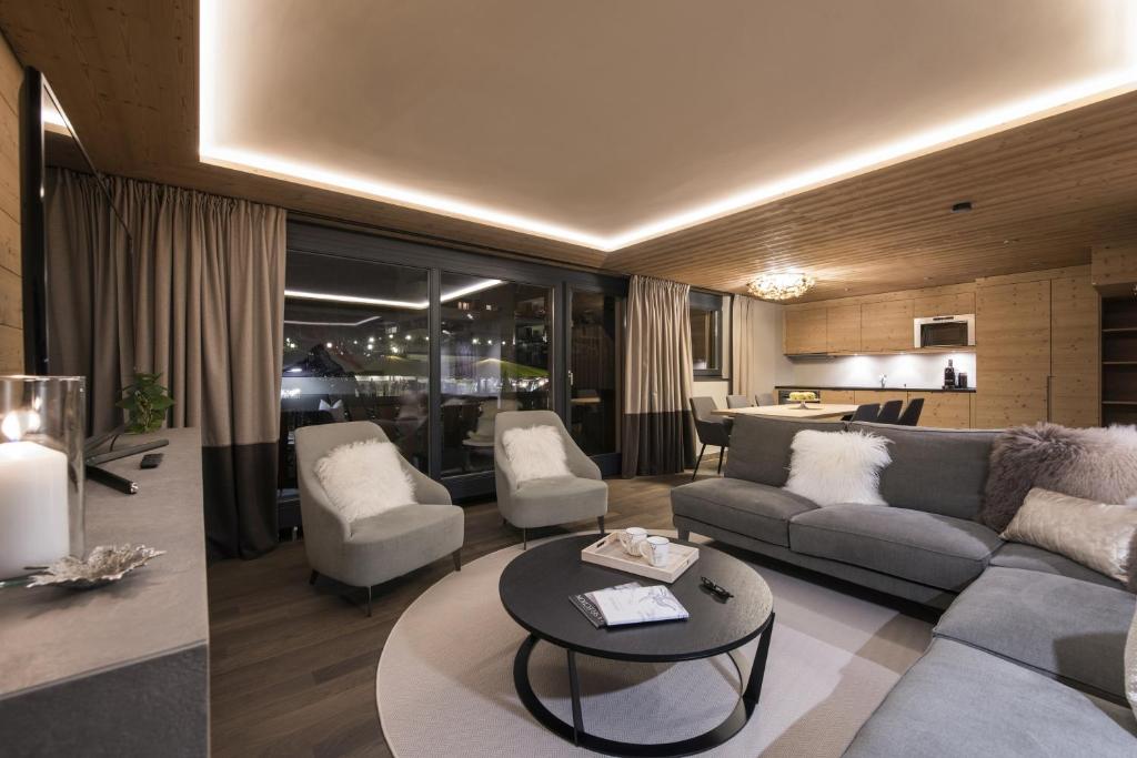 a living room with a couch and a table at Luxury Chalets & Apartments by Mountain Exposure in Zermatt