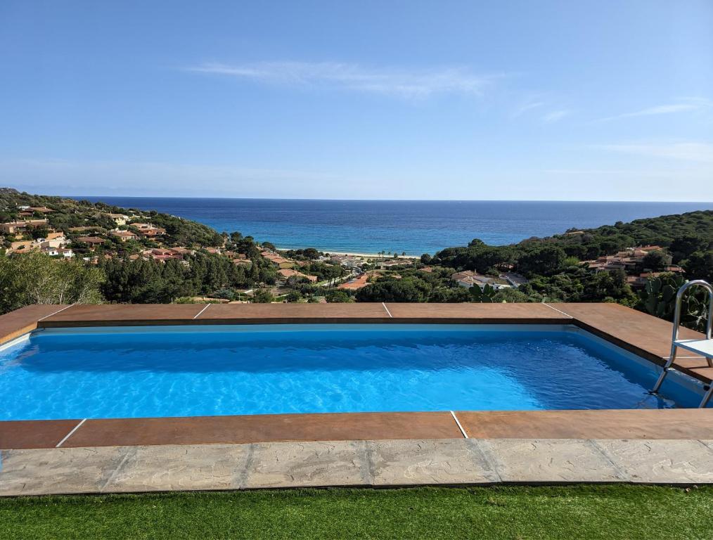 a swimming pool with a view of the ocean at Villetta con piscina panoramica Belvedere Mari Pintau in Geremèas