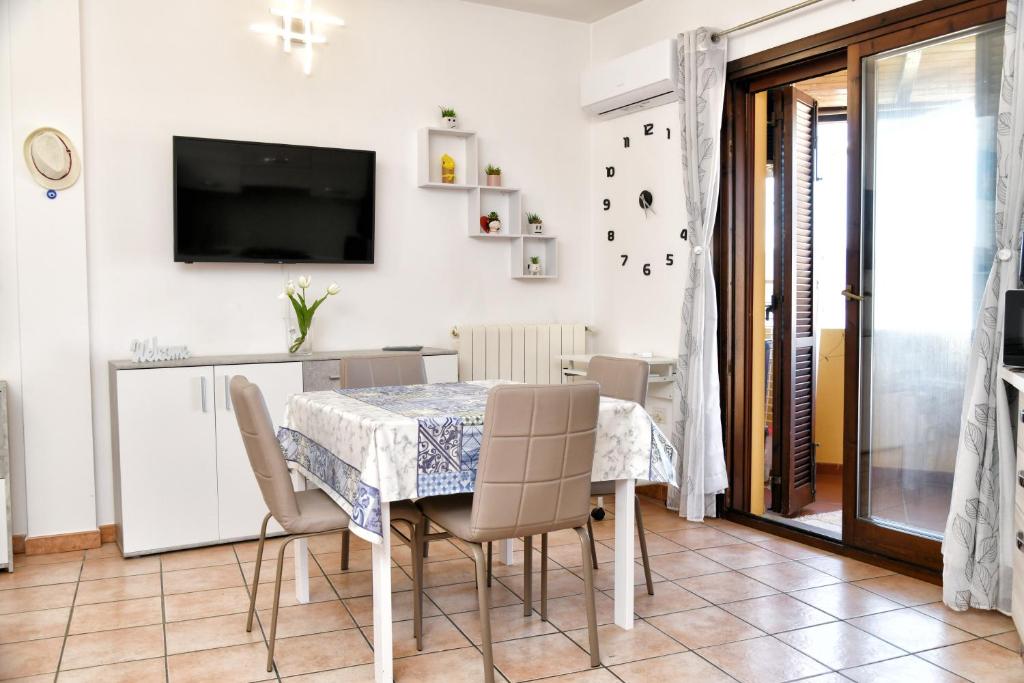 a dining room with a table and chairs at Perla Apartment con vista mare in Olbia