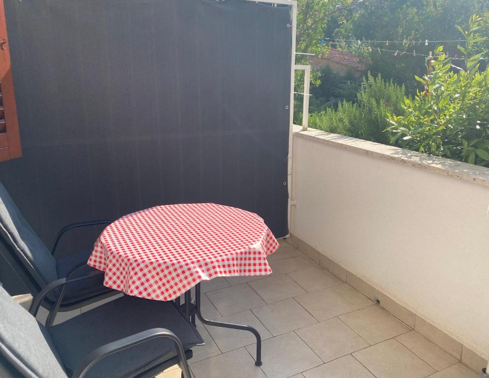 a table and chair with a red and white umbrella on a balcony at Guest House Marta in Rovinj