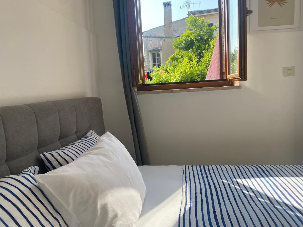 a bedroom with a bed and a window at Guest House Marta in Rovinj