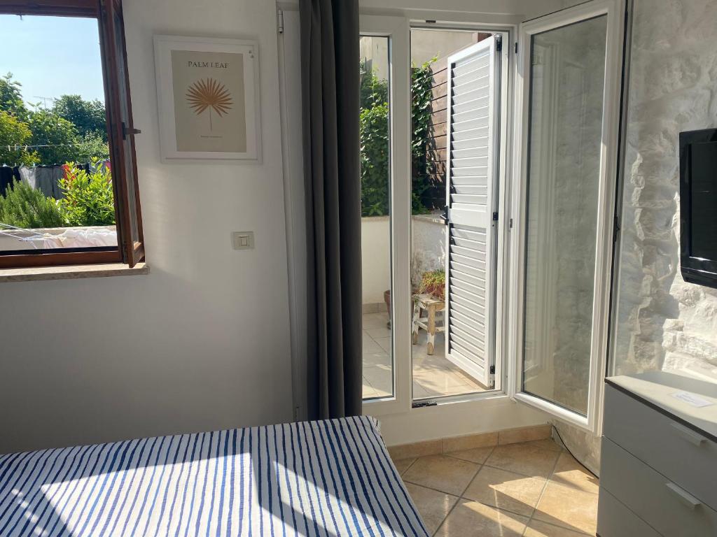 a bedroom with a sliding glass door to a patio at Guest House Marta in Rovinj