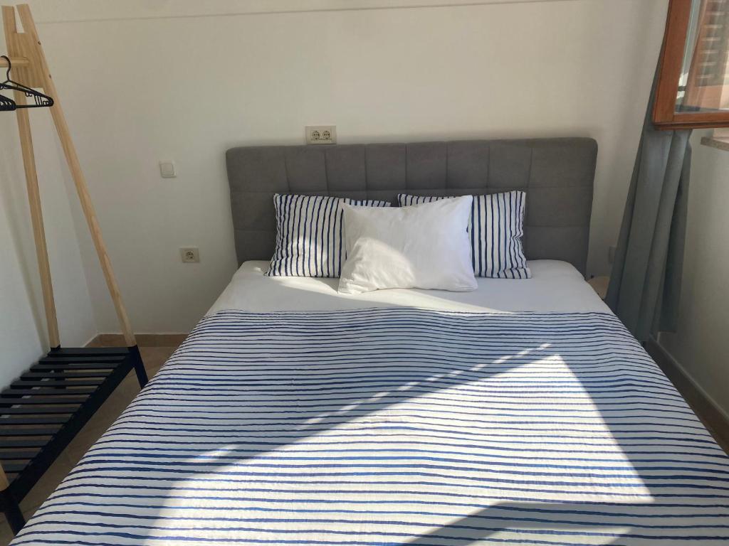 a bed with blue and white striped sheets and pillows at Guest House Marta in Rovinj