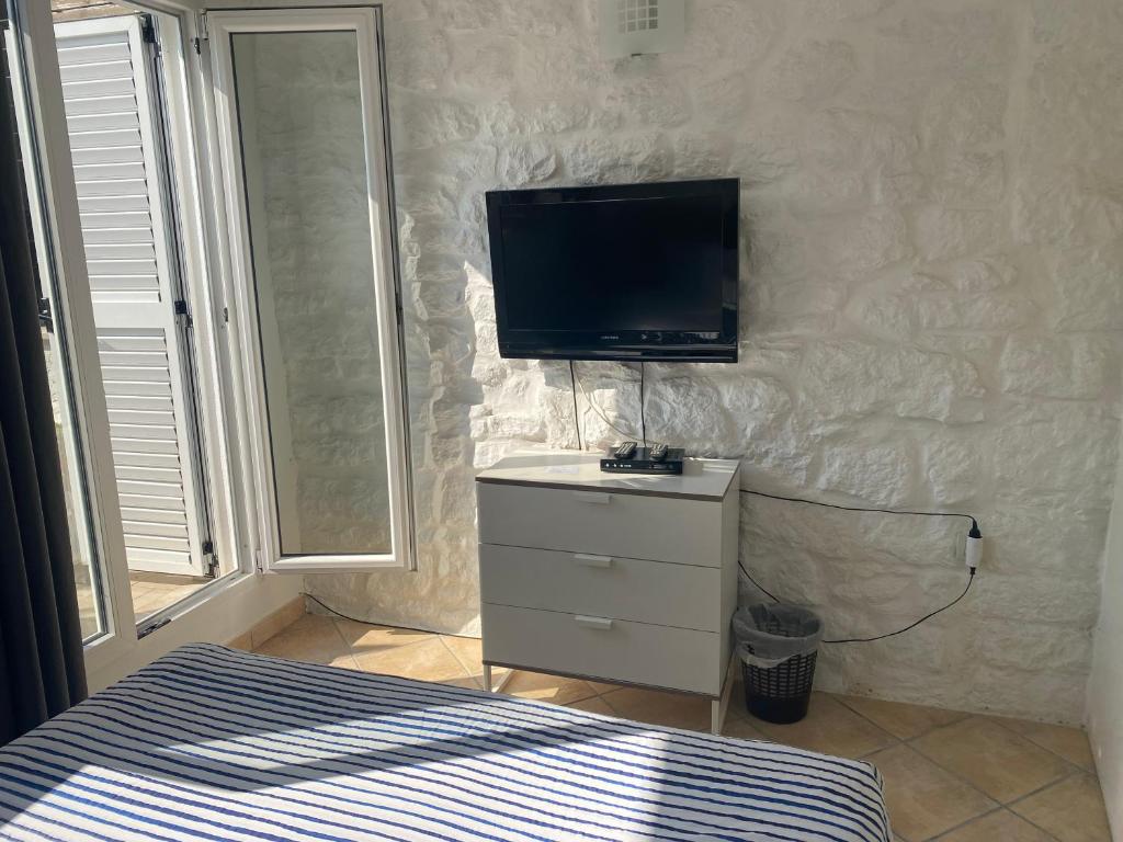 a bedroom with a bed and a tv on a wall at Guest House Marta in Rovinj