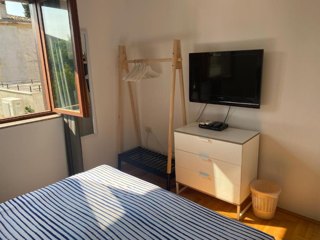a bedroom with a bed and a flat screen tv at Guest House Marta in Rovinj