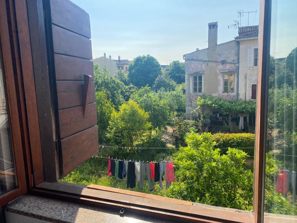 a window with a view of a garden with clothes hanging at Guest House Marta in Rovinj