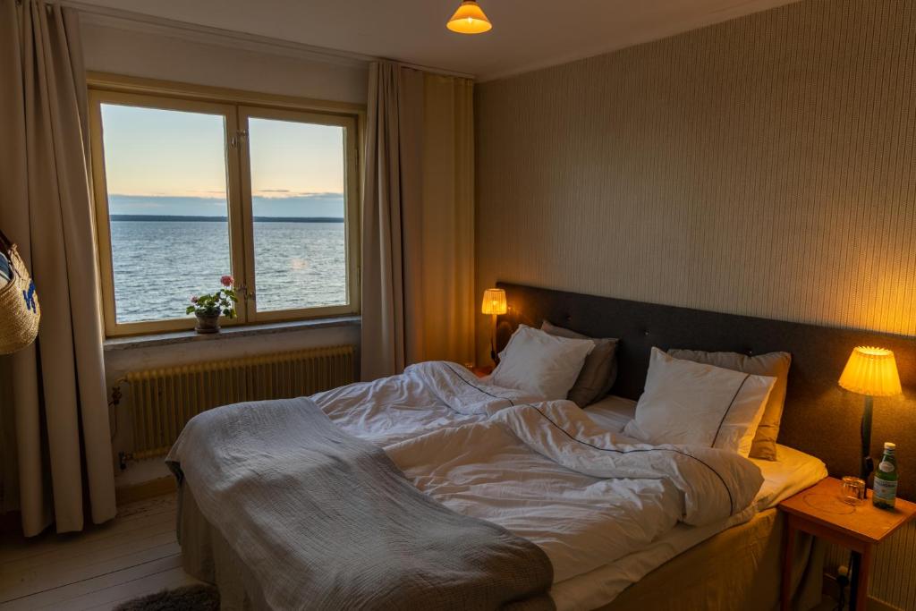 a bedroom with a large bed with a view of the ocean at Bungenäs Badhotell in Fårösund