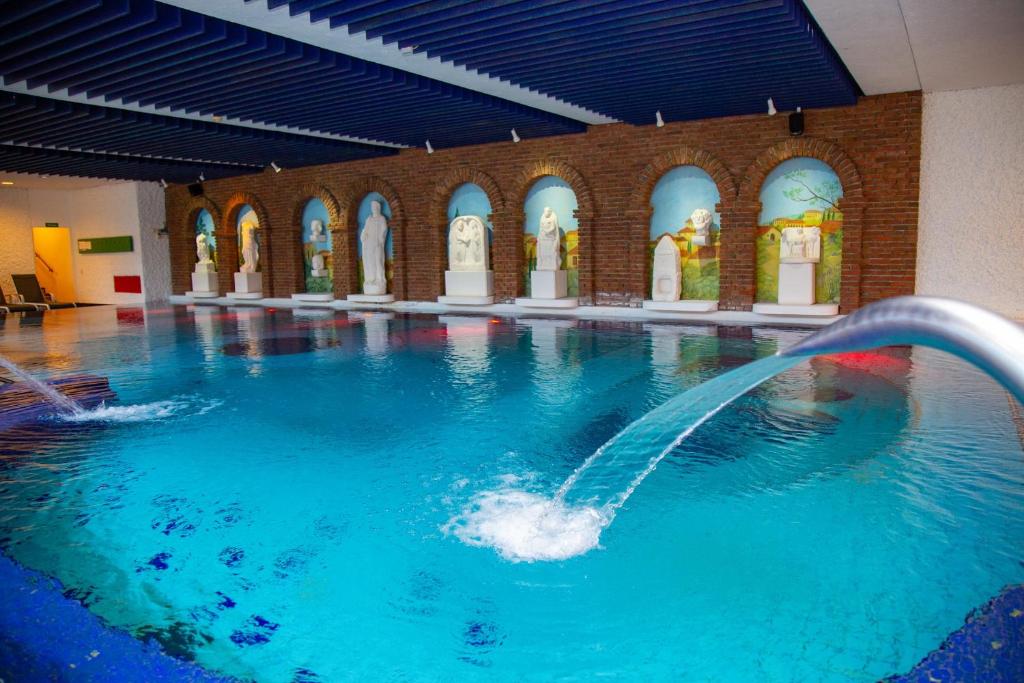a pool with a water fountain in a building at Fini-Resort Badenweiler in Badenweiler