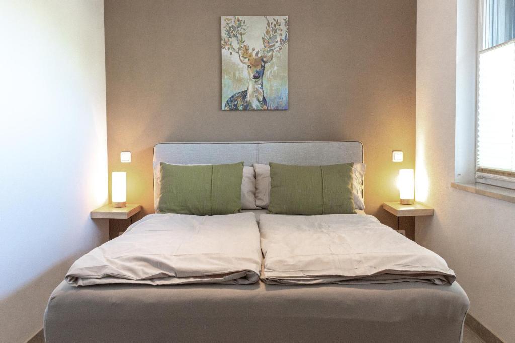a bedroom with a bed with two lamps on both sides at wolke 7, Bergblick Apartment, Kingsizebett & Schlafcouch, Balkon & Garten in Kiefersfelden