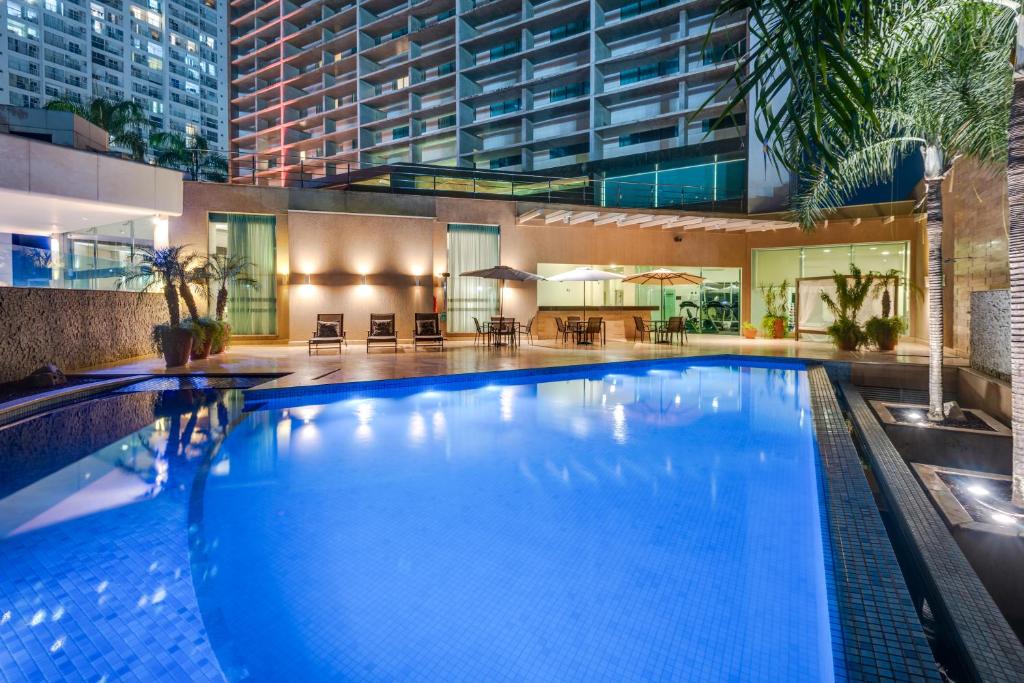 a large blue swimming pool in a building at K Hotel in Goiânia