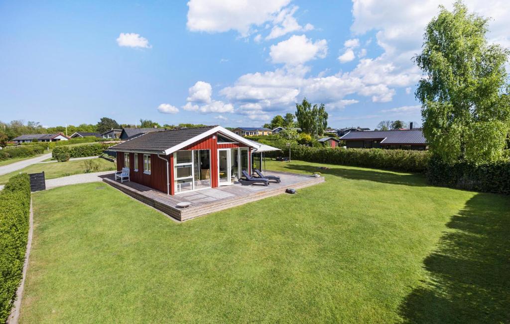 a small red house on a green lawn at Holiday Home Egernsund With A Fireplace 316 in Egernsund