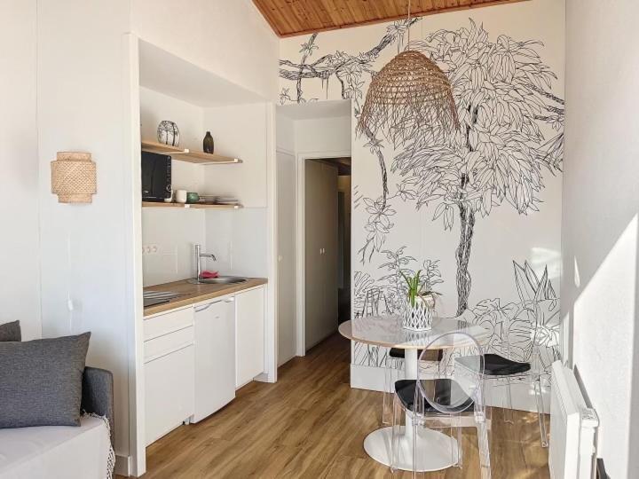 un salon avec une table et une cuisine dans l'établissement Appartement cosy, à Talmont-Saint-Hilaire