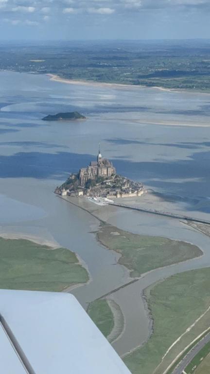 une île dans l'eau avec une église sur celle-ci dans l'établissement Les 3 couronnes, à Granville
