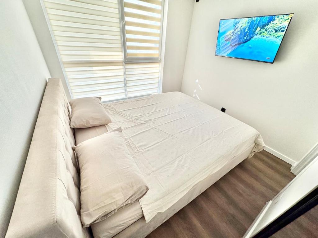 a bed in a small room with a window at Комфортная квартира на Ботанике in Chişinău