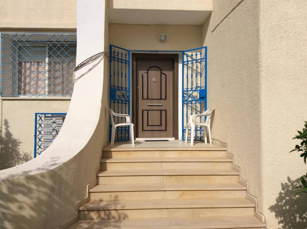 un conjunto de escaleras que conducen a una casa con puerta en Villa Kenza, en Nabeul