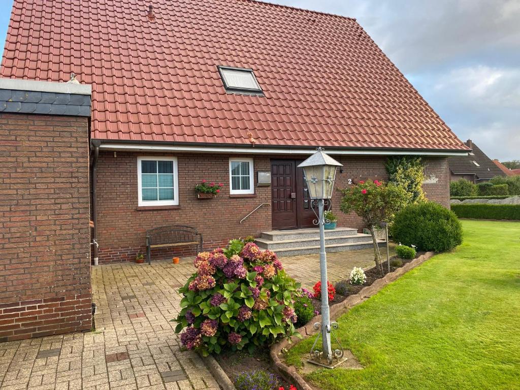 ein Haus mit rotem Dach und Straßenbeleuchtung in der Unterkunft Haus Hanni Ferienwohnung Hanni in Hage Ostfriesland direkt am Kiessee und Kurpark - Nordseenah in Berumbur