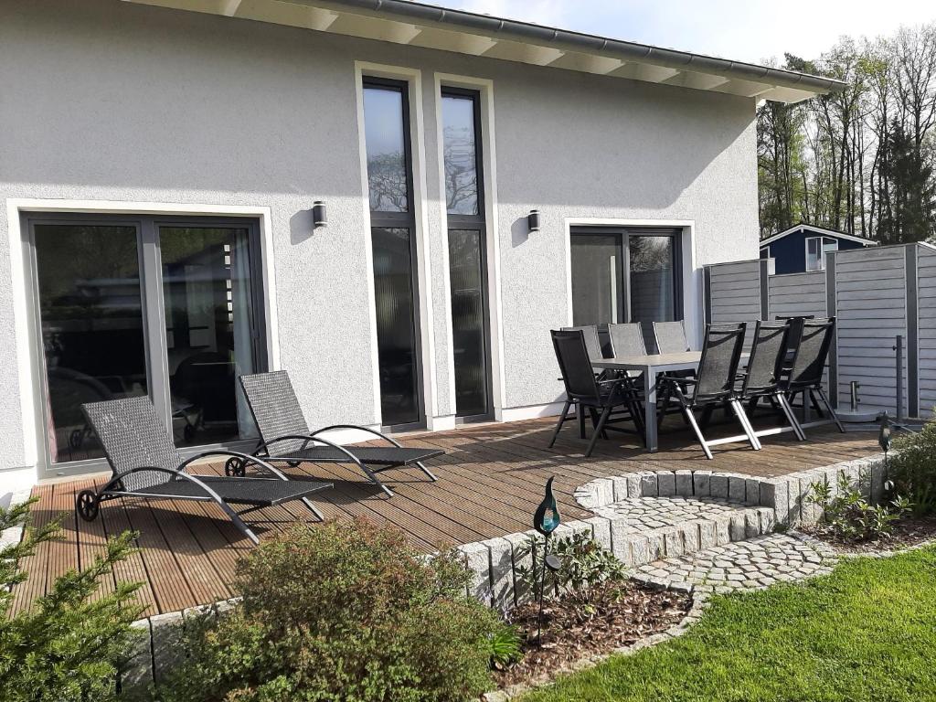 un patio con sedie e tavolo di fronte a una casa di Ferienhaus Vanessa Für 8 Personen a Dümmer