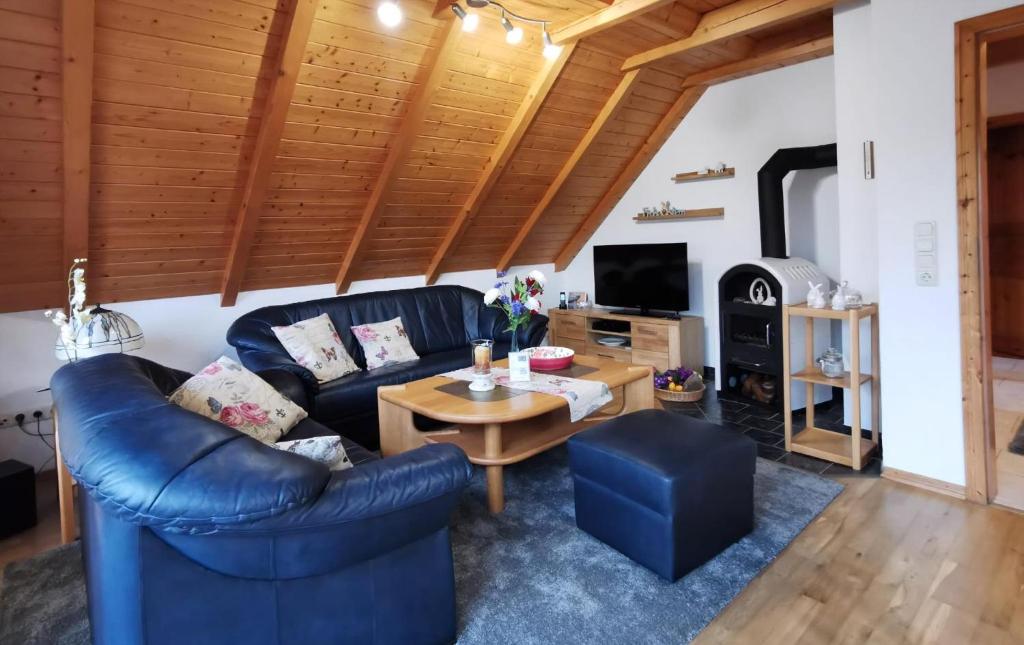 a living room with a blue couch and a table at Wohnung In Wilhelmsfehn Mit Großem Balkon in Wiesmoor