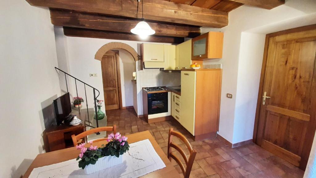 a kitchen and dining room with a table with flowers on it at La Corte in Pratovecchio